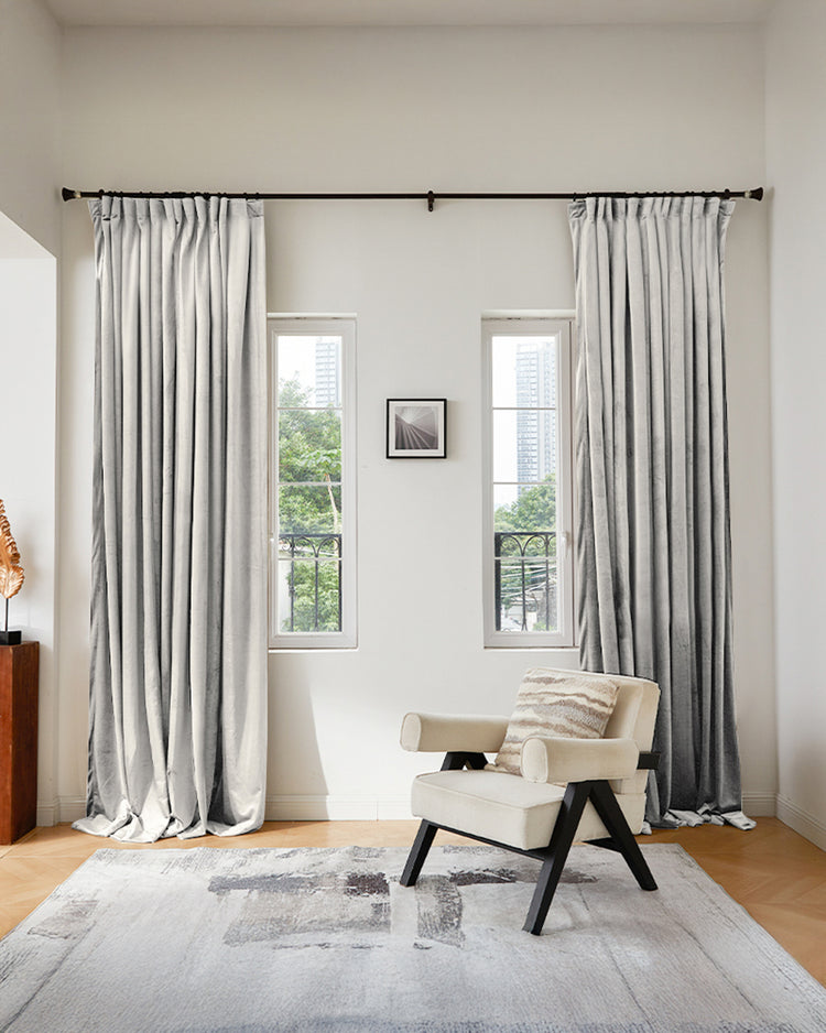 Light gray Moonlit Shimmering Velvet custom curtains, floor-length drapery on a dark rod, enhancing a sophisticated room.