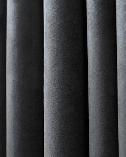 Close-up of the thick, dark grey velvet texture of a custom blackout curtain, emphasizing its heavyweight and luxurious feel.