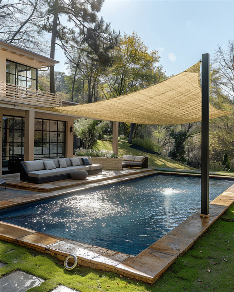 Custom beige breathable rectangle sun shade sail sheltering a modern outdoor patio with poolside seating and a sparkling pool.