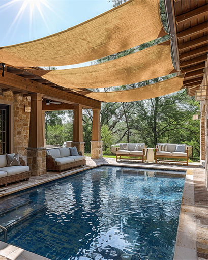 Tan HDPE breathable custom rectangle sun shade sails sheltering a resort-style swimming pool.