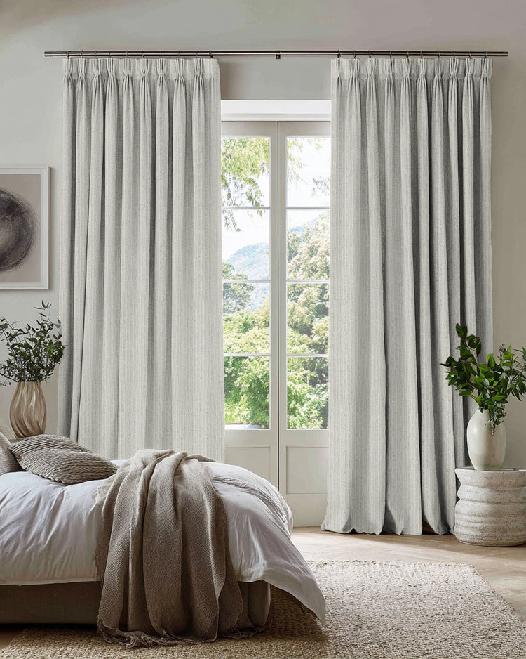 Elegant Liwa Linen Blend patterned custom drapery with a pinch pleat header in a serene bedroom, offering light control.
