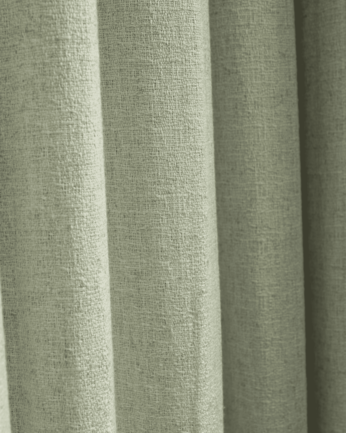 Soft sage green Fiona linen blend custom curtain fabric close-up, highlighting its natural weave texture and elegant drape.