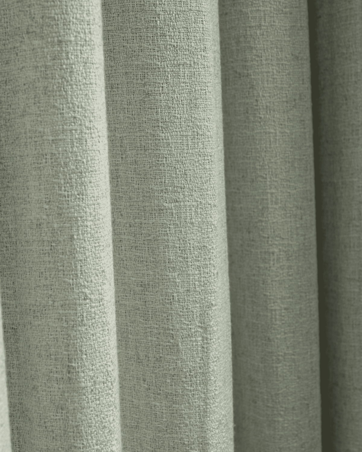 Close-up of Fiona Linen Blend custom curtain fabric in sage green, highlighting its textured weave and elegant drape.