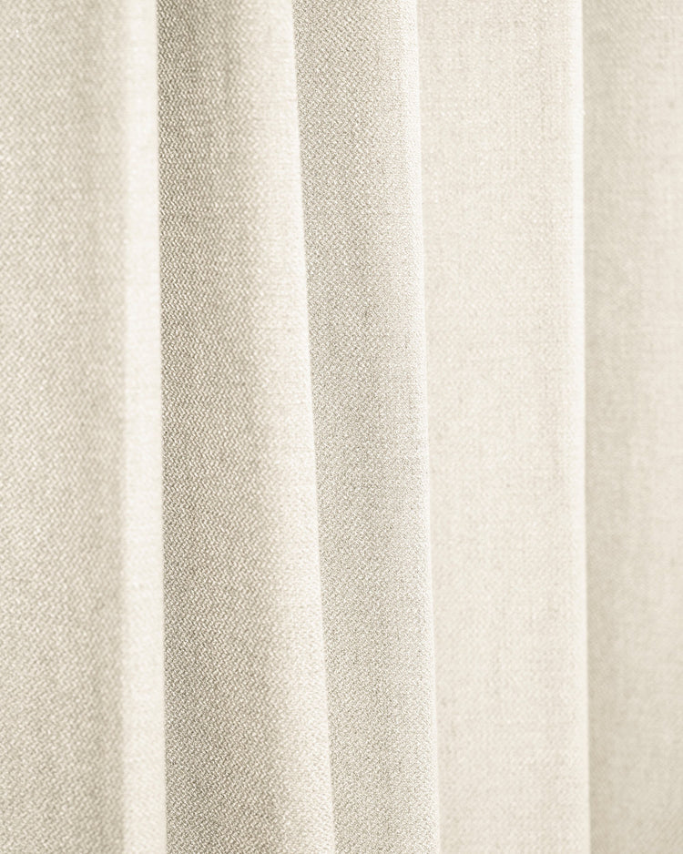 Close-up of TheHues Iris textured custom drapery in a soft cream color, highlighting the exquisite fabric weave & elegant folds.