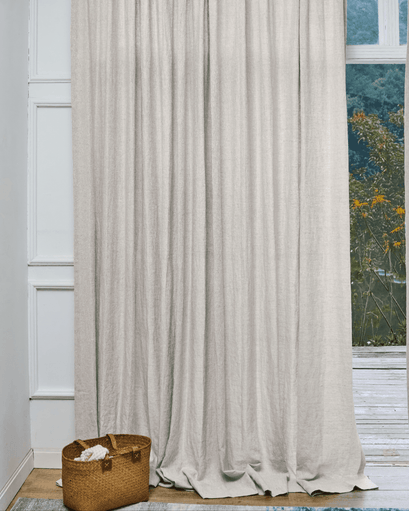 Tahiti pure linen custom drapery in light beige, artfully draped for sophisticated home aesthetics & gentle light control by a window.