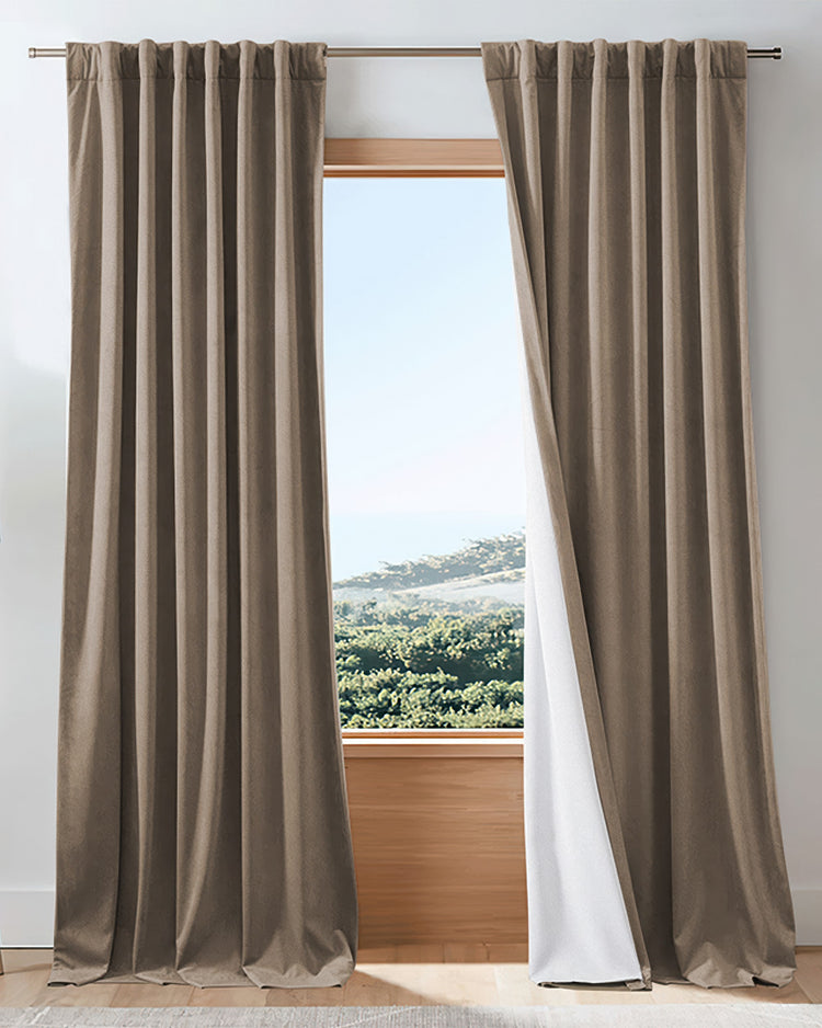Elegant brown velvet 100% blackout custom drapery, revealing white thermal lining against a scenic window.