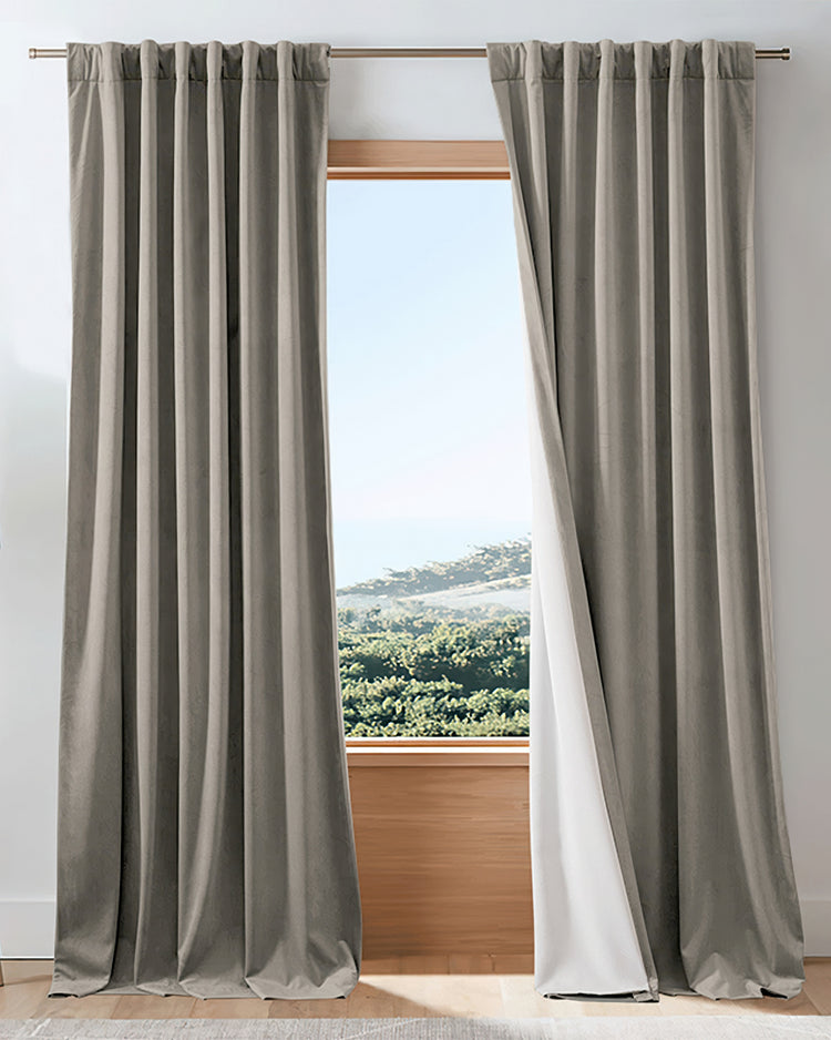 Taupe velvet 4-layer heavyweight custom blackout drapery panels with tailored pleats & white thermal soundproof lining at a window.