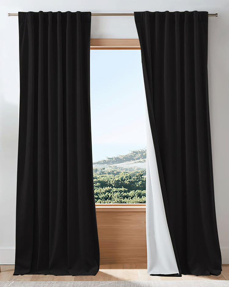 Black velvet 4-layer 100% blackout custom curtains partially open, revealing white lining & bright outdoor view.