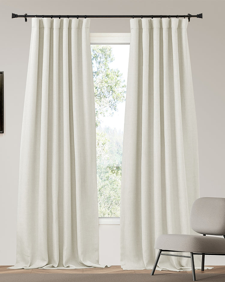 Off-white Zoe custom 4-layer linen look blackout curtains, heavyweight, thermal, & soundproof, gracefully hanging in a bright room.