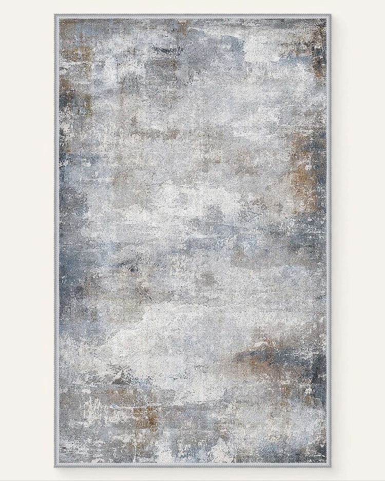 Faded Mystic Clouds washable area rug featuring a distressed abstract pattern in grey, white, and earthy blue-brown hues.