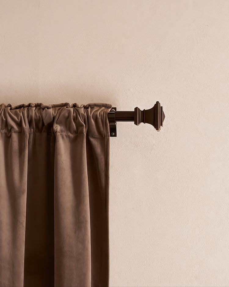 Brown velvet rod pocket curtain on a custom brown curtain rod with a decorative Roman square finial for elegant window treatments.