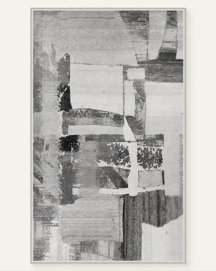 Abstract geometric vintage Tara dark gray washable area rug featuring a distressed pattern of gray, black, and white blocks.