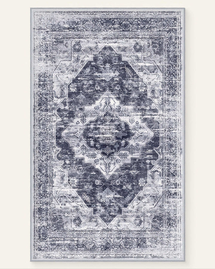 Diana's Garden denim blue washable area rug with a distressed medallion and intricate floral-like patterns.