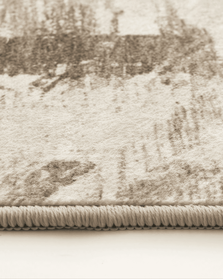 Plush texture and vintage geometric pattern of the Tara neutral washable area rug, showing distressed detail and edge binding.