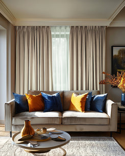 Tailored Laborien linen look custom drapery in light taupe, offering light control, enhances a sophisticated living room with elegant furnishings.