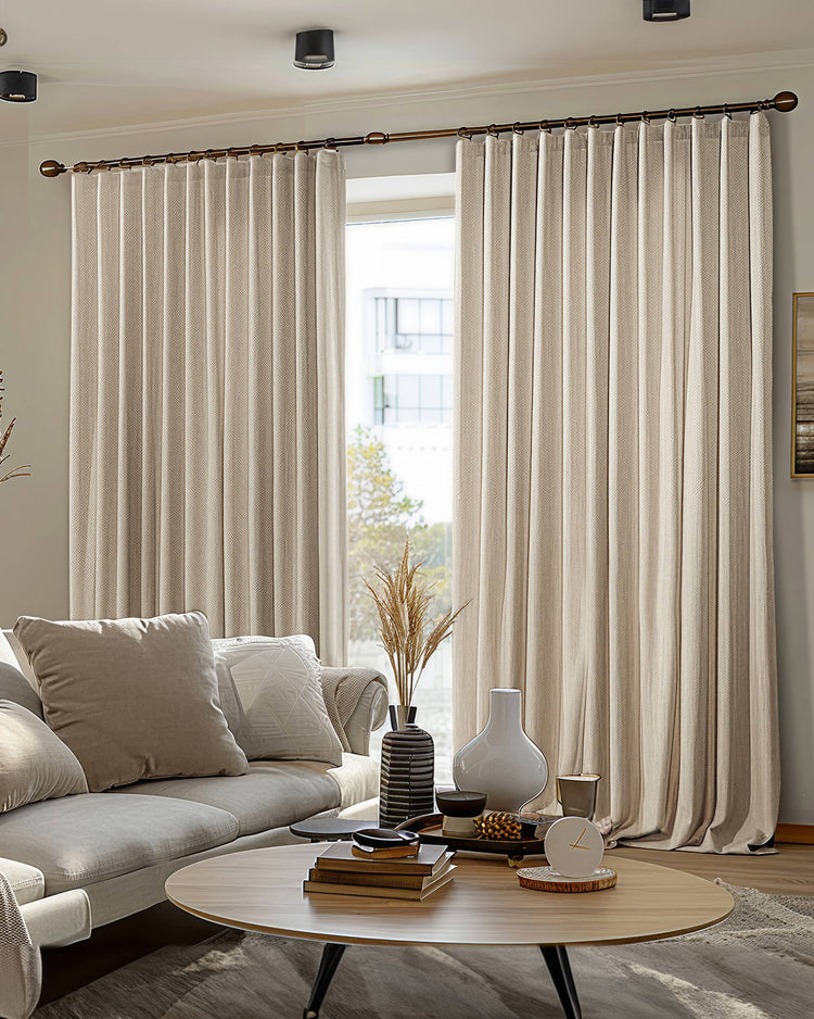 Light beige Florence woven textured custom pleated blackout drapery drawn in a modern living room, enhancing privacy and light control.