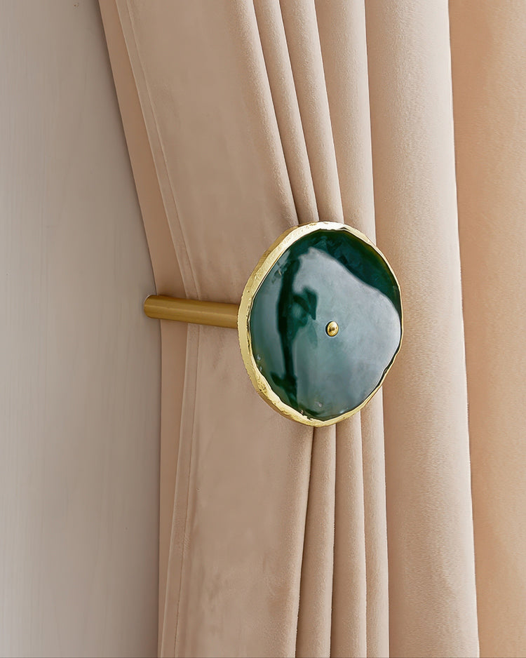 Elegant gold-edged dark green natural crystal curtain wall hook securing luxurious beige velvet drapery for refined home decor.