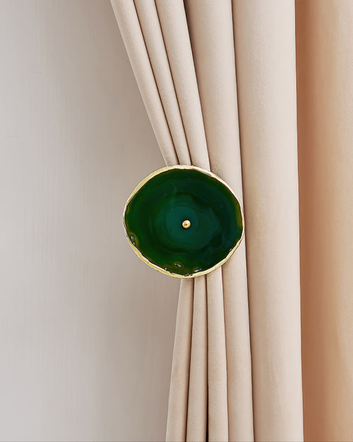 Elegant green natural crystal curtain wall hook securing a tailored beige velvet drapery for sophisticated home decor.