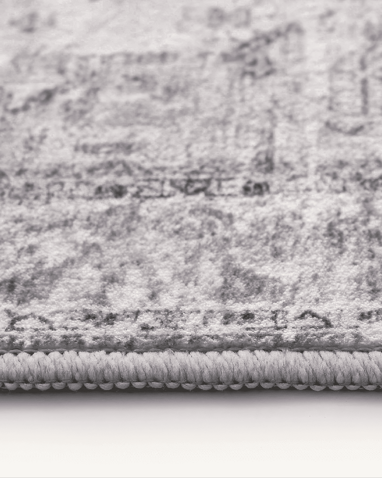 Close-up of Diana's Garden Gull Gray washable area rug, showcasing its soft pile texture and neatly bound edge.