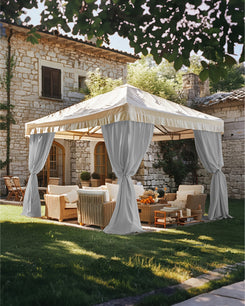Lightweight, fade-resistant custom gray outdoor curtains tied back on a cream gazebo, defining a luxurious outdoor living area.