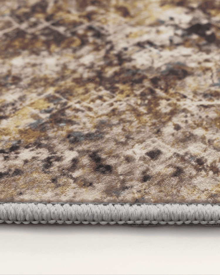 Close-up of a Vintage Faded Moroccan Washable Area Rug edge, showing detailed grey binding and distressed multi-color pattern.