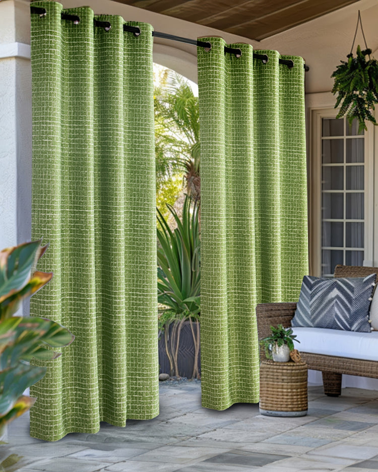Custom green New York Grid patterned textured waterproof outdoor grommet curtains on a sunny patio with outdoor furniture.