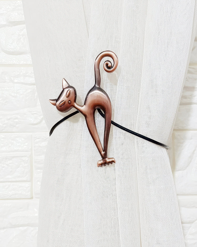 Stylized bronze cat magnetic curtain tieback gathering a white textured linen-blend drapery panel, demonstrating its elegance.