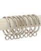 Close-up of polished silver metal curtain rings with eyelets on a rod, for custom drapery & window treatments.
