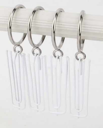 Four silver curtain rod eyelet rings with white drapery pin hooks hanging from a rod for custom window treatments.
