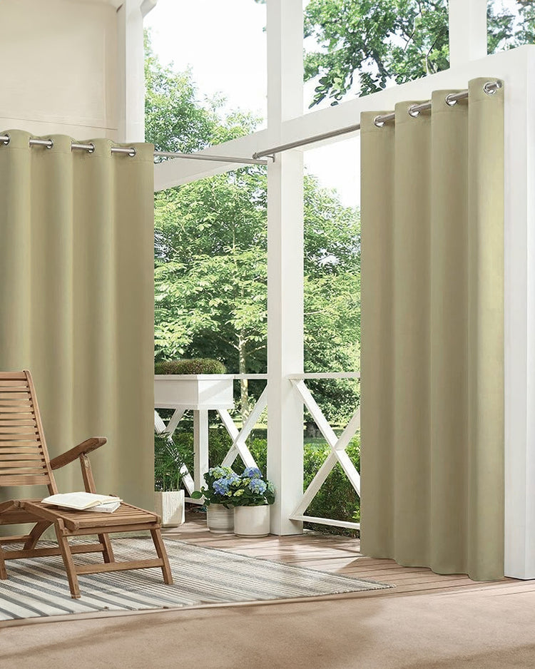 Khaki custom waterproof outdoor curtains with grommet tops hang on a patio, enhancing privacy and creating a stylish outdoor retreat.