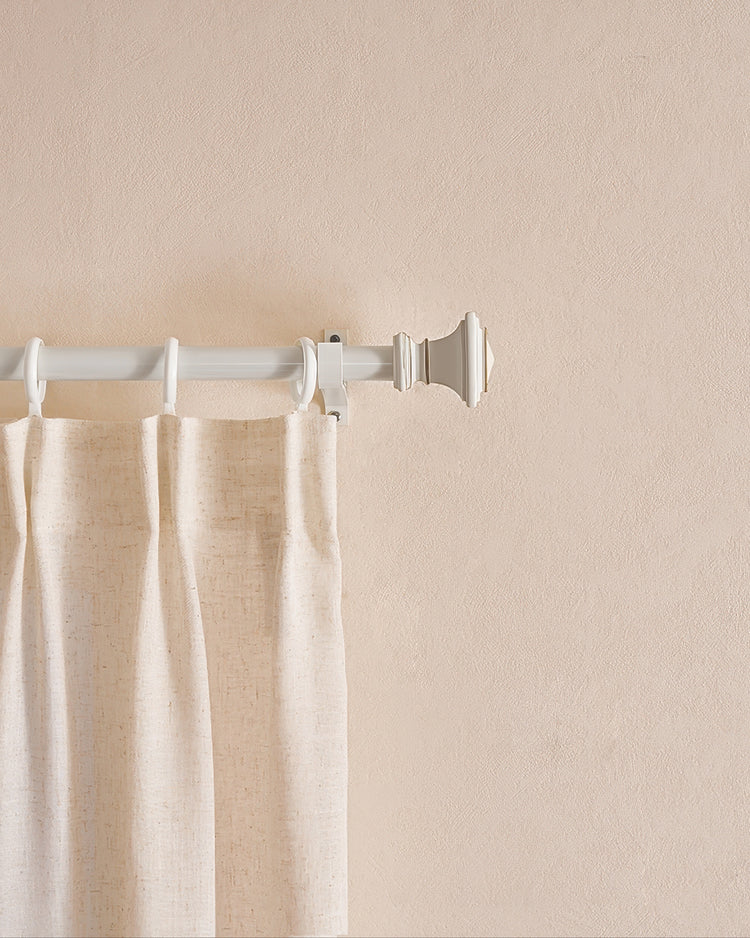 Close-up of a white custom Roman Square finial curtain rod with a light-colored drape hanging by rings