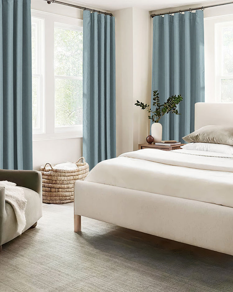 Bedroom with custom blue herringbone chenille blackout curtains on ring top hardware, perfect for privacy and light control.