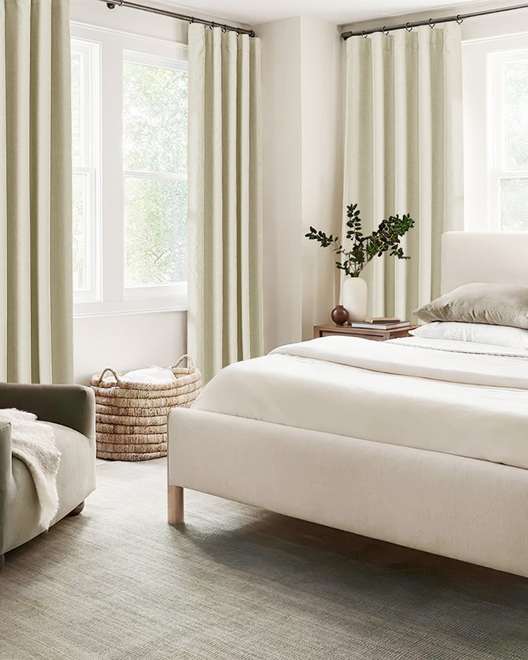Cream herringbone chenille custom blackout curtains frame a bright bedroom window, enhancing decor & privacy.