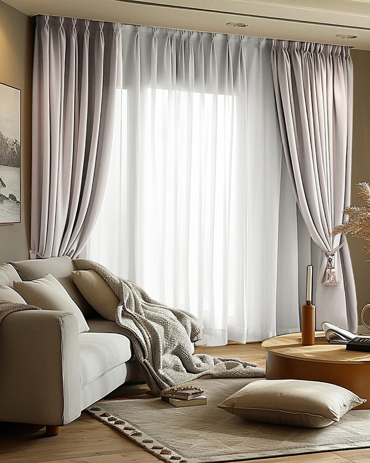 Light grey Victoria 100% blackout linen look custom curtains, pinch pleat header, tied back, layered with sheers in a living room.