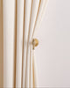 High-end cream velvet drapery gracefully held by a golden bird metal curtain wall hook, enhancing sophisticated home decor.