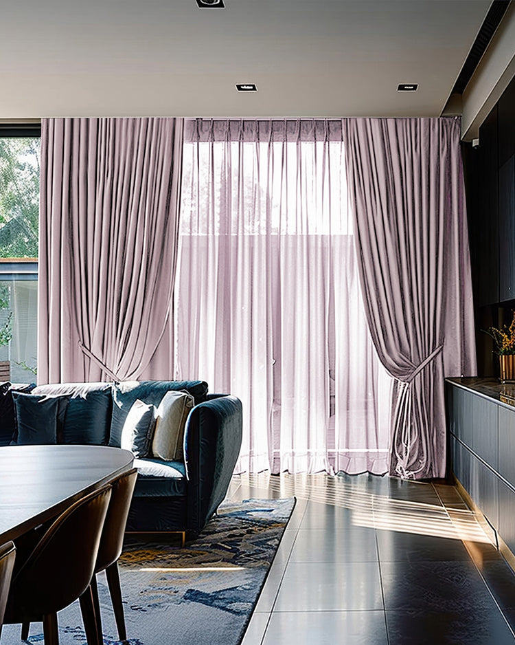 Quinn 4-layer heavyweight thermal dusty rose velvet custom blackout curtains, tied back, layered with sheers on a living room window.
