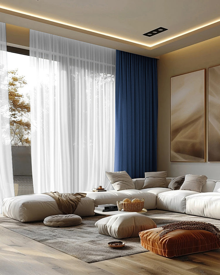 Custom deep blue velvet blackout drapes & sheer white curtains on tall living room windows, providing elegant privacy & light control.