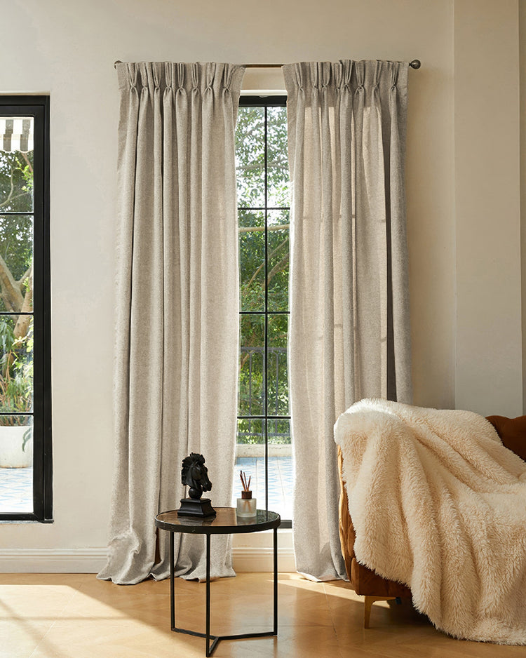 Two long, textured beige jacquard custom curtains with pinch pleat, perfectly tailored for elegant window treatments.