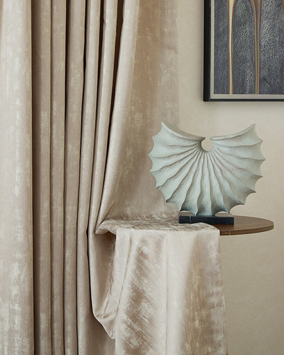 Champagne glimmer linen blend lightweight textured custom drapery, elegantly draped with a decorative shell sculpture on a side table.