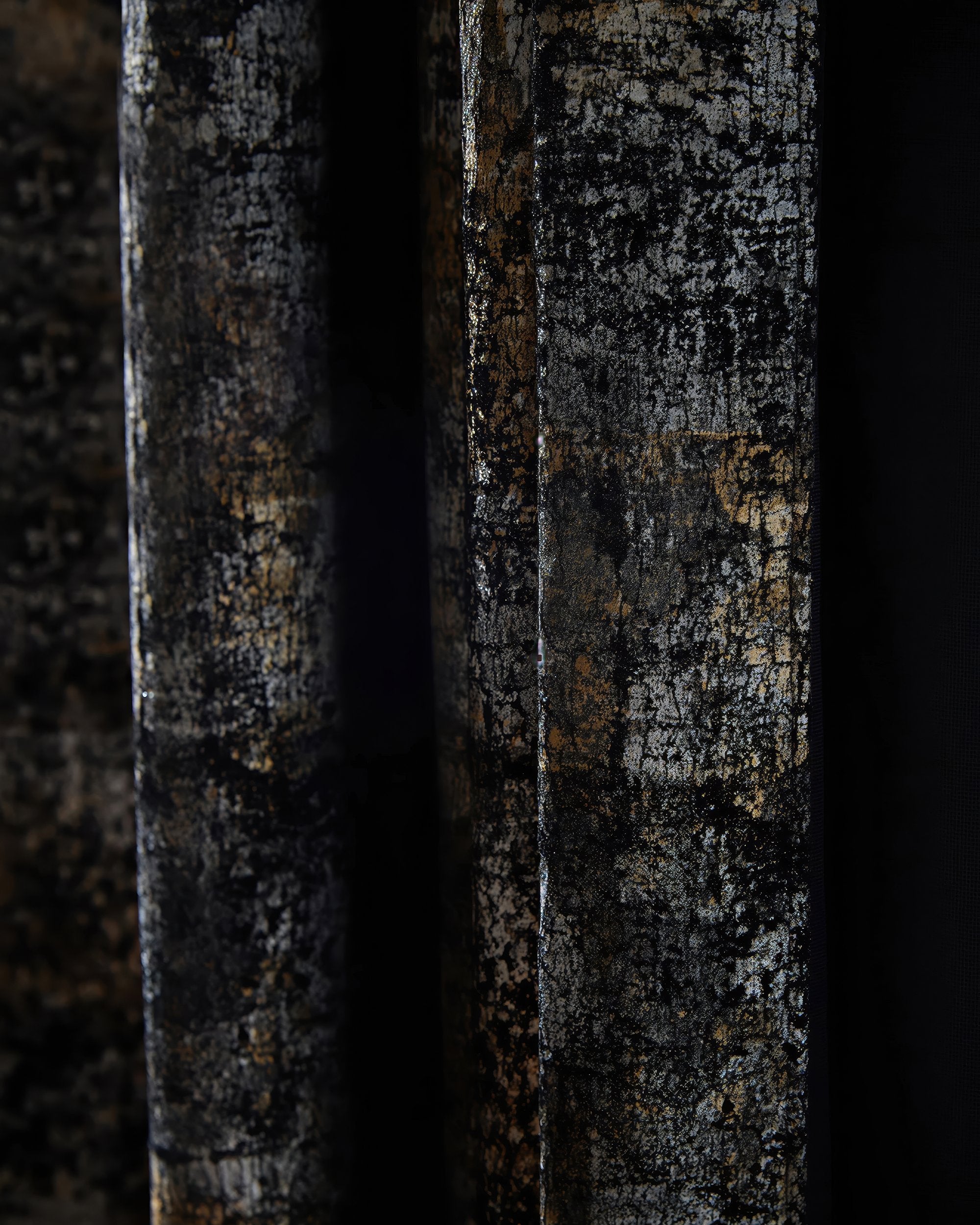 Close-up of luxurious custom velvet drapery, featuring a dark Impression foil printed pattern with shimmering metallic gold and silver details.
