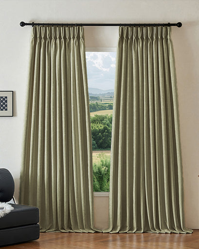 Ambient heavyweight sage green jacquard custom blackout curtains with elegant pleats, partially open to reveal a scenic view.