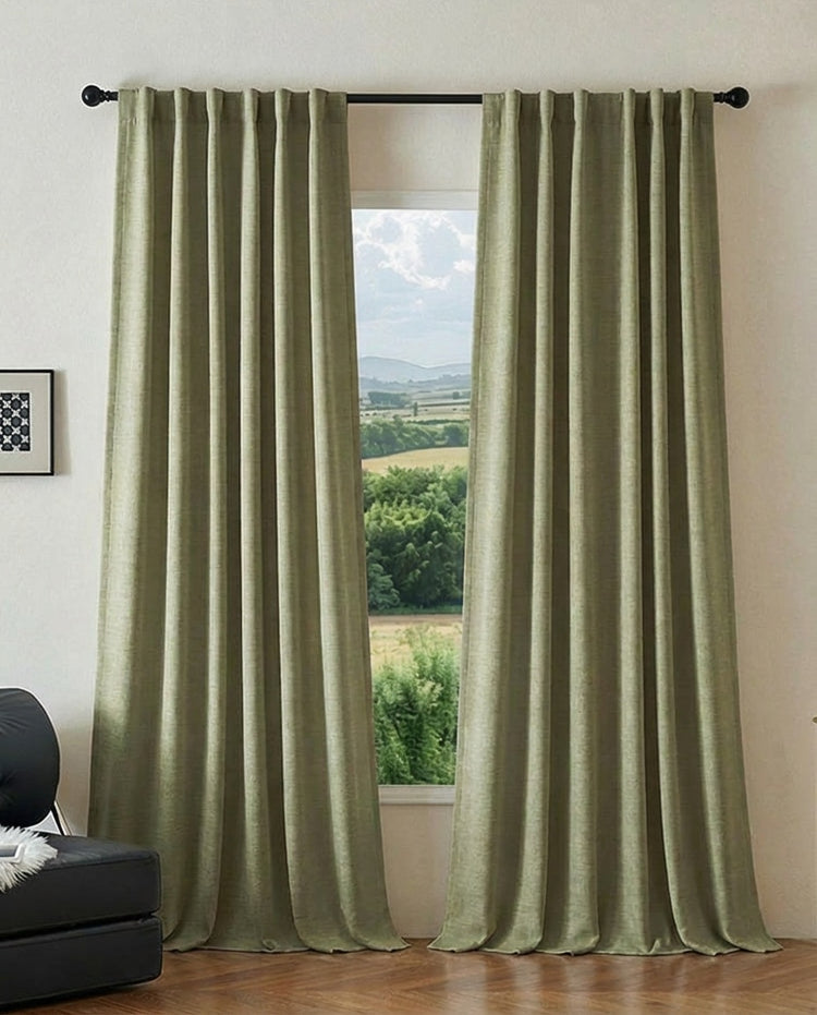 Ambient heavyweight sage green jacquard custom blackout curtains with elegant pleats, partially open to reveal a scenic view.