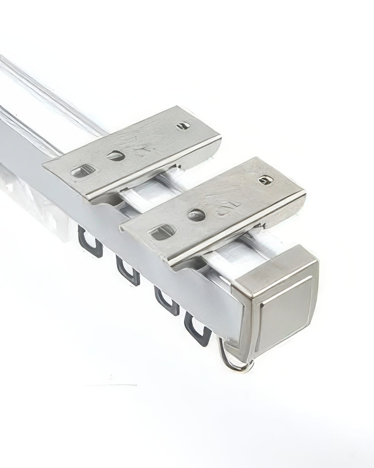 Close-up of the silver heavy-duty metal curtain track with gliders and mounting brackets, highlighting the magnetic closing end cap.