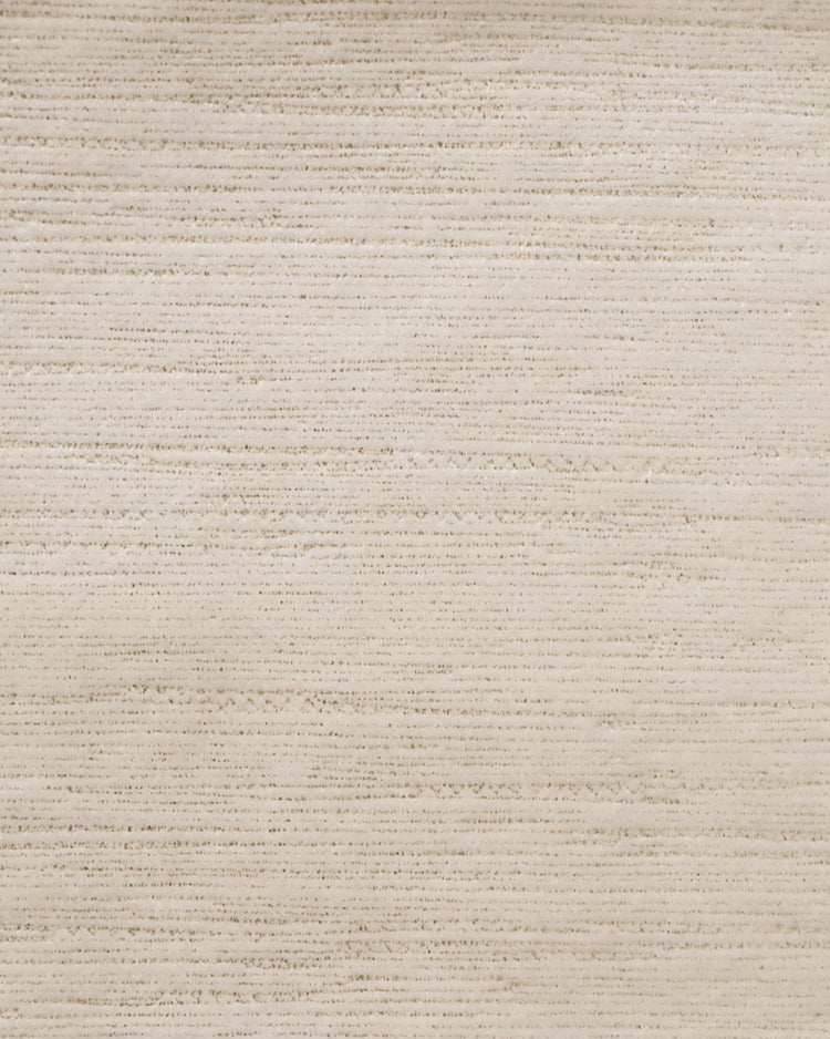 Close-up of elegant light beige custom velvet curtain fabric with subtle, shimmering horizontal foil print texture.