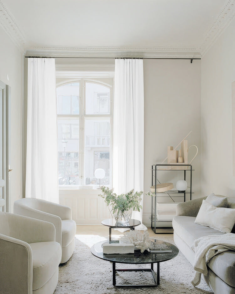 Floor-length Traunsee cotton blend custom sheer curtains frame an arched window in a luxurious, sunlit living room.