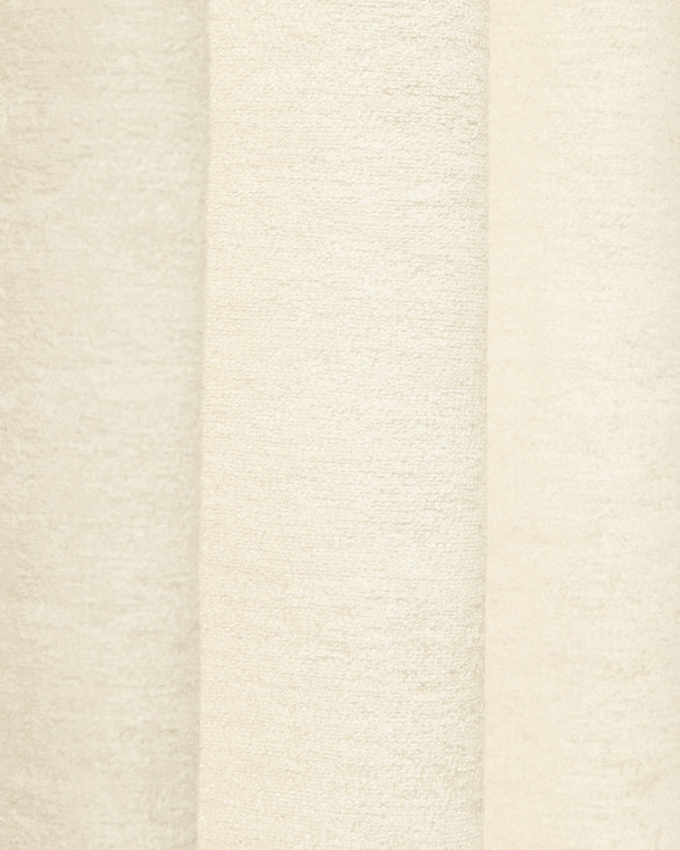 Close-up of Ambient Jacquard custom curtain in creamy white, showcasing intricate fabric texture & alternating vertical weaves.