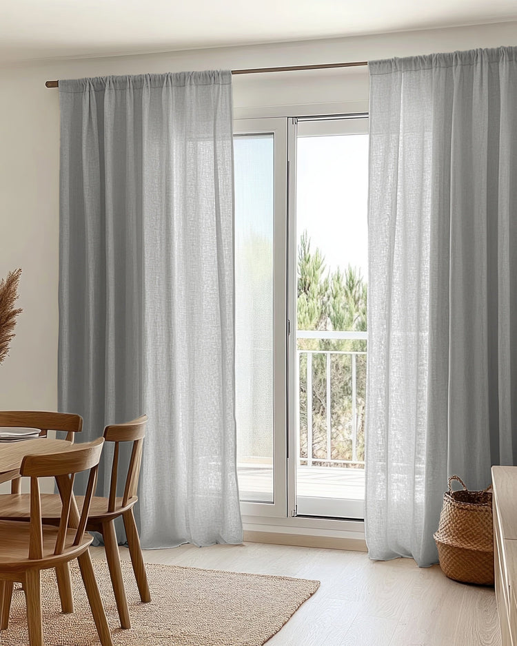 Light grey yarn linen look sheer custom curtains with rod pocket header, offering soft light filtering over a patio door in a modern home.