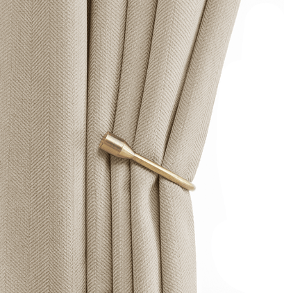 Bronze decorative curtain holdback securing a light beige custom drapery panel with a textured weave.