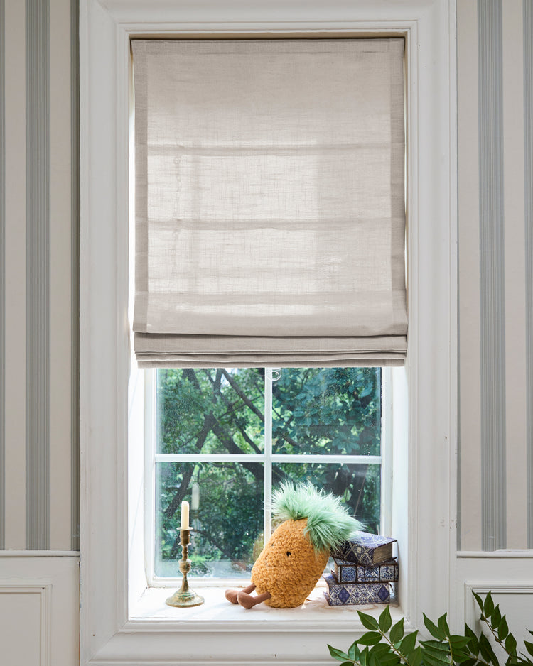 Elegant Cassie Flat Fold Linen Blend Custom Roman Shade in a window, showcasing its crisp folds and textured fabric for sophisticated light control.
