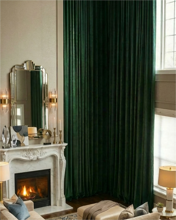 Floor-to-ceiling forest green custom velvet curtains in a luxury living room beside a white marble fireplace.